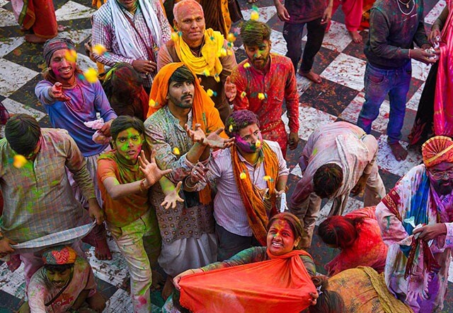 बरसाना के राधा रानी मंदिर में सोमवार, 27 फरवरी, 2023 को 'लड्डू होली' के उत्सव के दौरान मिठाई लेने की कोशिश करते लोग. (पीटीआई फोटो/कमल किशोर)