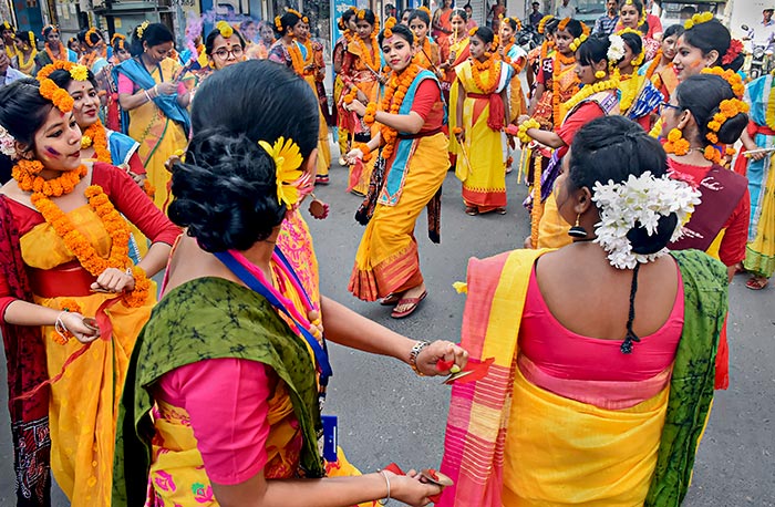 रंगों के त्योहार होली की पूर्व संध्या पर मुर्शिदाबाद जिले के एक स्कूल में 'बसंत उत्सव' मनाते छात्र. फोटो: पीटीआई