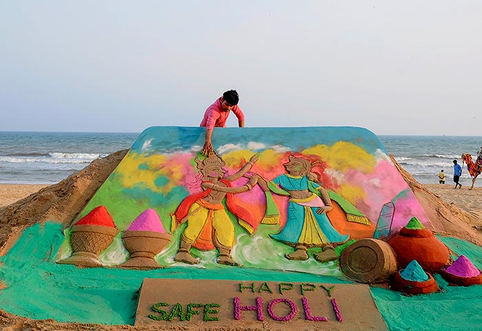 सेंड आर्टिस्&zwj;ट मानस साहू ने 'होली' के त्योहार के अवसर पर पुरी में रेत पर आकृति बनाई. फोटो: पीटीआई