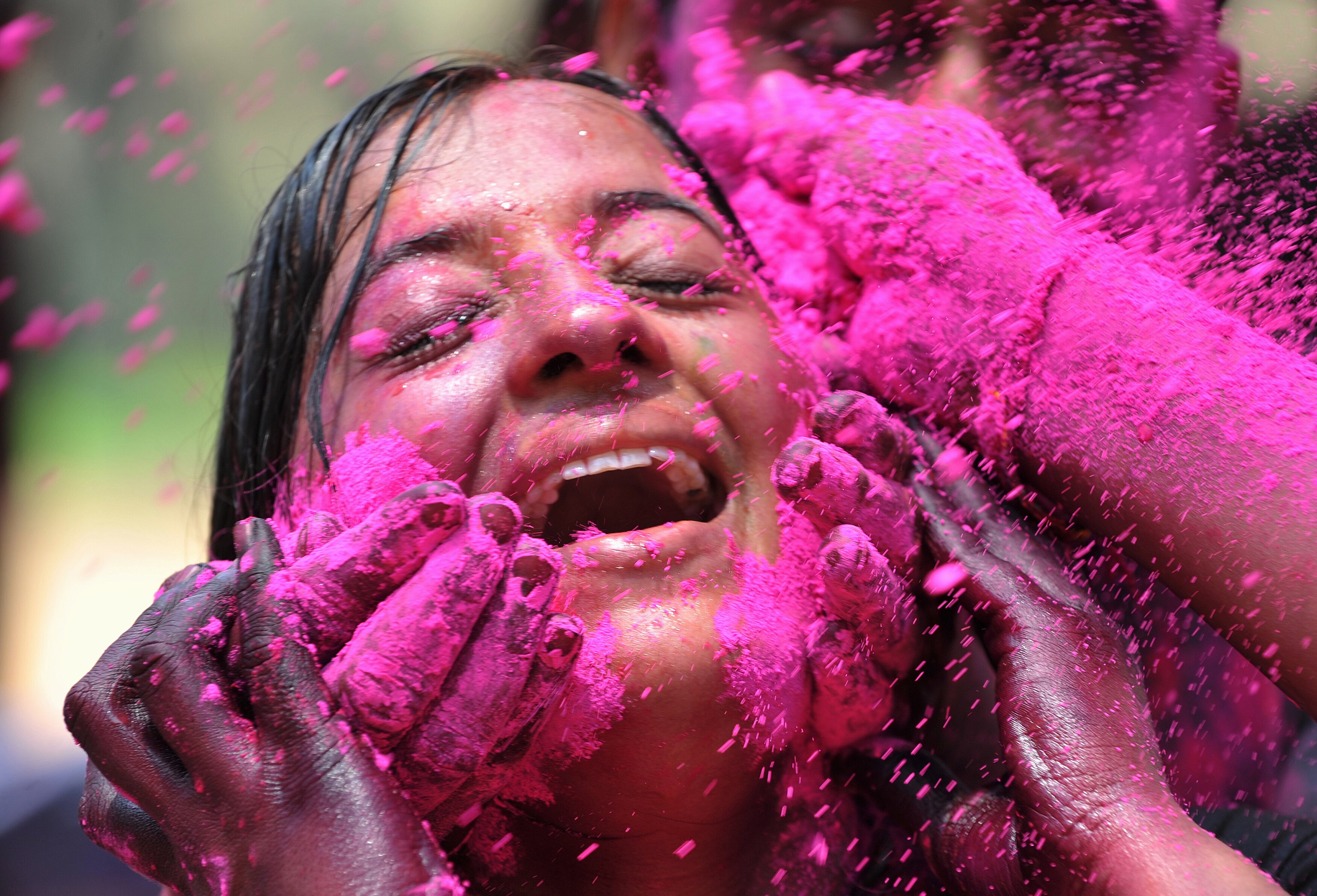 A woman has her face smeared with coloured powder during Holi celebrations in Hyderabad. (AFP Photo)