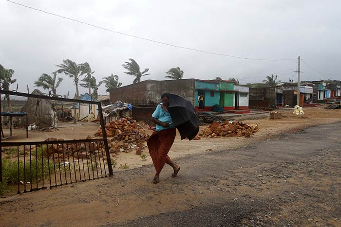 A villager walks towards a shelter as heavy rain and wind gusts rip through the Bay of Bengal coast at Gopalpur, Odisha.