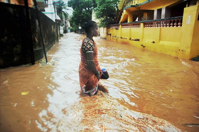 A woman wades through a water logged street after cyclone Hudhud caused heavy rains in Bhubaneswar on Sunday