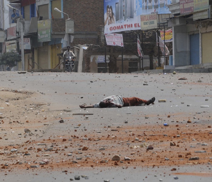 An injured man lies on the road after clashes in the Old City area of Hyderabad. Incidents of stabbing, arson, stone pelting, attacks on places of worship, shops and vehicles were reported from over a dozen areas. (AP photo)