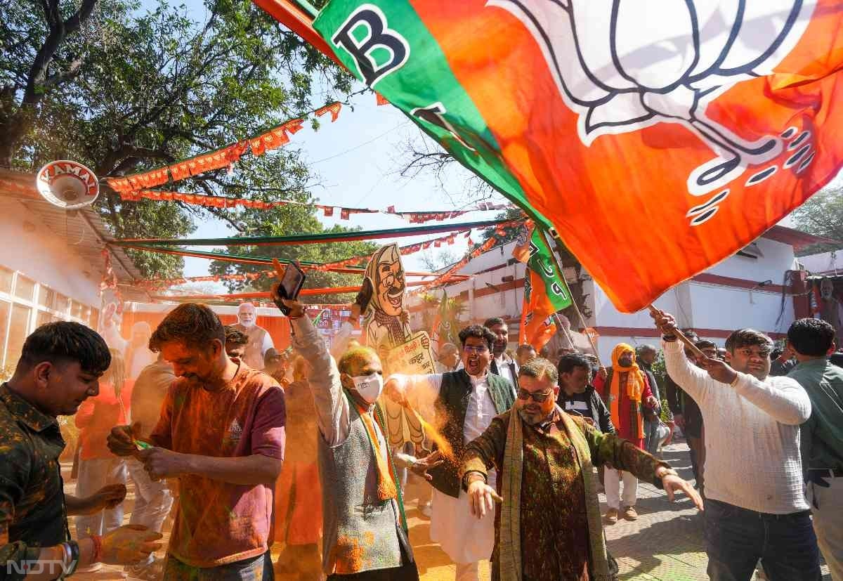 BJP supporters celebrate massive win in Delhi polls outside BJP office in New Delhi.