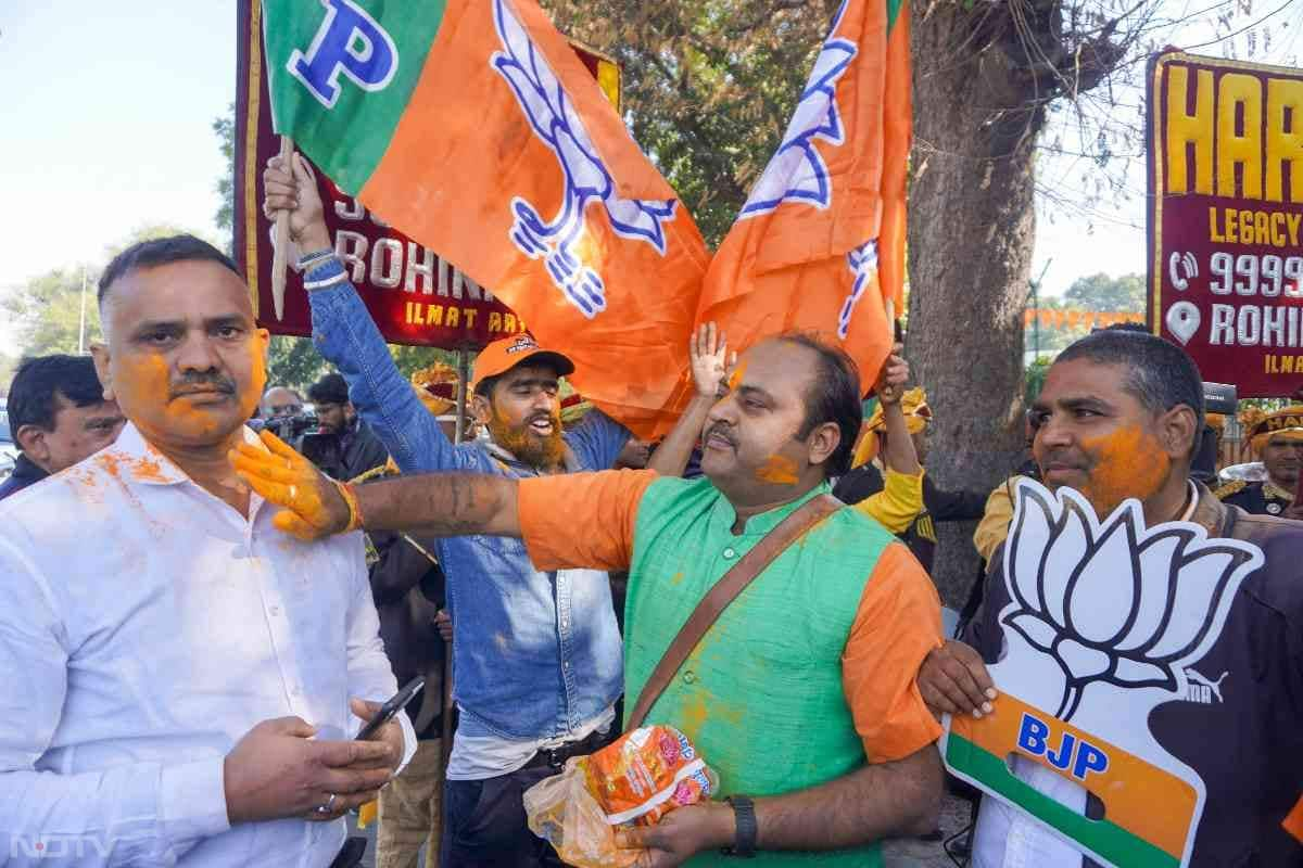 BJP supporters celebrate outside party office in New Delhi as it returns to power in the national capital.