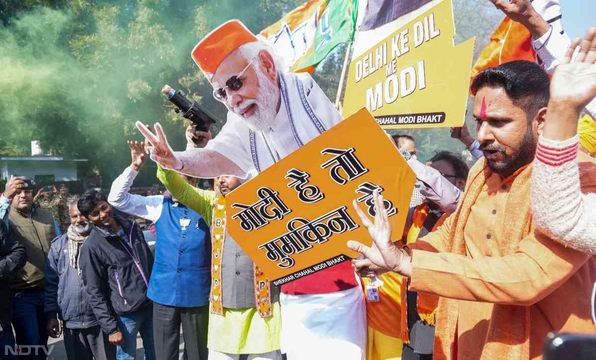 BJP supporters holding PM Modi's portrait as they celebrate party's big win in Delhi.