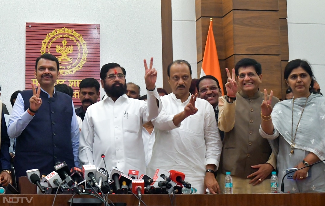 Maharashtra Chief Minister Eknath Shinde, Deputy Chief Ministers Ajit Pawar, and Devendra Fadnavis, and Union Minister Piyush Goyal show a victory sign during a press conference