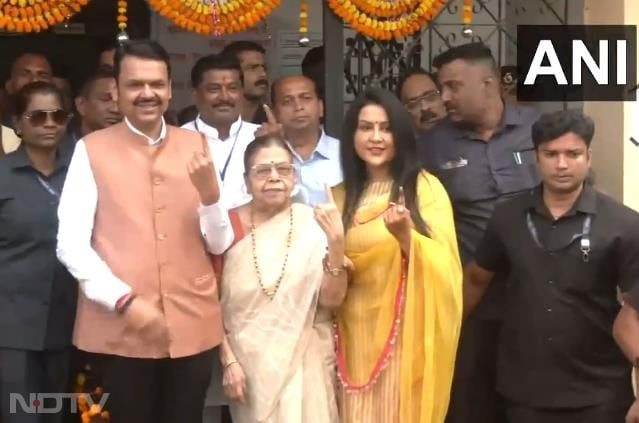 Maharashtra deputy chief minister Devendra Fadnavis, wife Amruta Fadnavis and mother Sarita Fadnavis show their inked fingers after voting in Nagpur