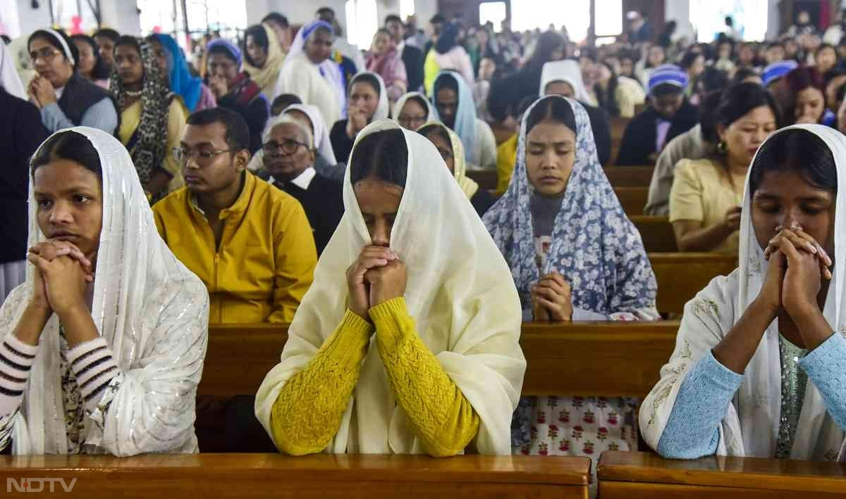 Christian devotees pray during Christmas celebrations at a church in Guwahati