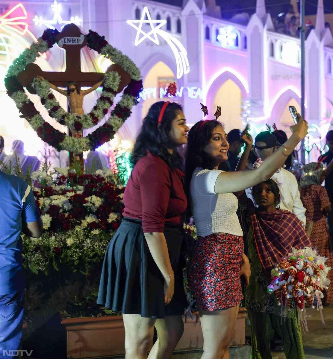 Devotees take a selfie in front of Mount Mary Church on Christmas Eve in Mumbai