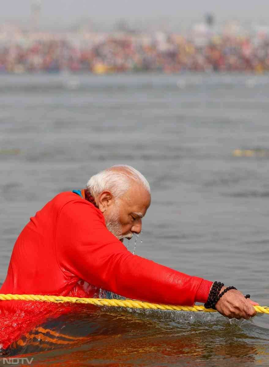 Wearing a bright saffron jacket and blue trackpants, and holding 'rudraksha' beads, he chanted prayers as he took several full body dips in the river waters