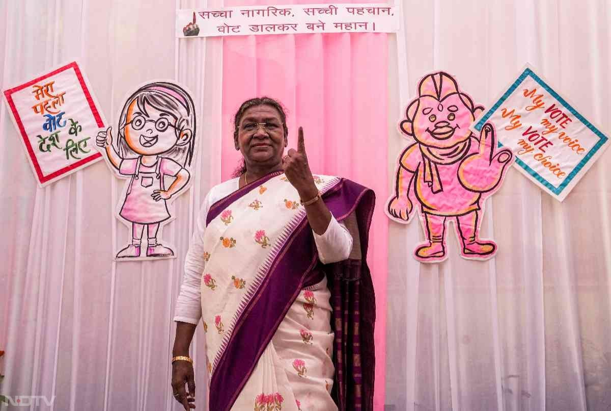 President Droupadi Murmu shows her inked finger after casting her vote at a polling booth in New Delhi