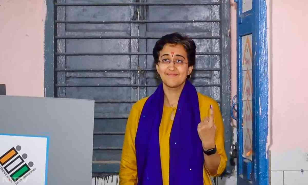 Delhi Chief Minister and AAP candidate Atishi shows her inked finger after casting her vote at a polling booth in Kalkaji