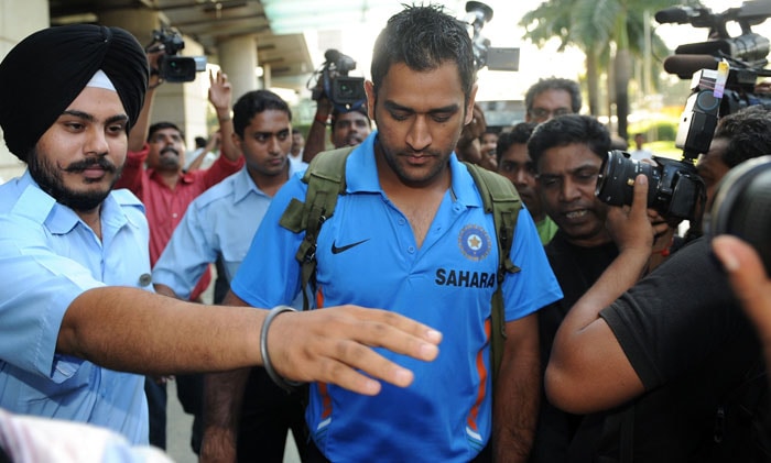 Mahendra Singh Dhoni is escorted to the team bus in Mumbai on September 18. India left for South Africa keen to maintain their consistency to fulfill their fans' expectations at the Champions Trophy from September 22 - October 5. (AFP Photo)