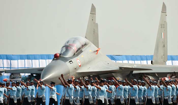 Cadets march past a plane.