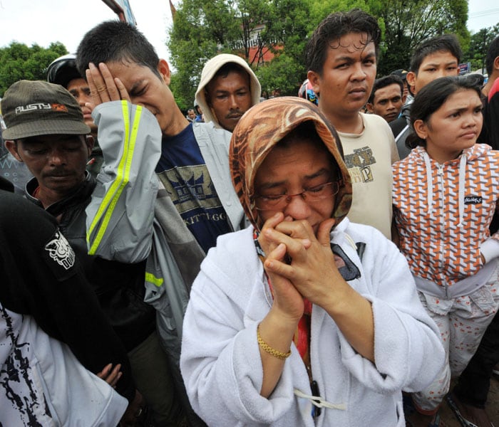 Family members mourn victims in front of a collapsed school in Padang, West Sumatra, on October 1, 2009 after a 7.9 strong earthquake hits the area. AFP PHOTO