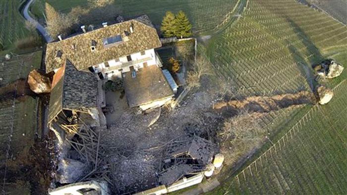 A huge boulder is seen after it missed a farm house by less than a meter, destroying the barn, and stopped in the vineyard, in Ronchi di Termeno, in Northern Italy.