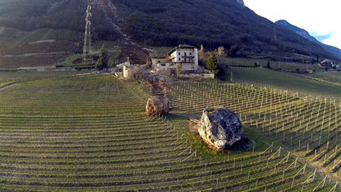 The two boulders are seen near the farmhouse after they tumbled down a mountain during a landslide.