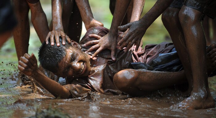 A visually impaired child plays in a mud-pit in celebration after breaking the 'dahi-handi'. (AFP Photo)