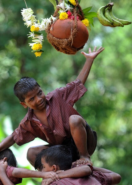 A child tries to reach the 'dahi handi' during the Janmashtami celebration. (AFP Photo)