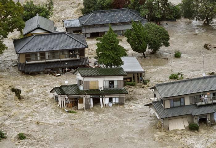 People look at a river flowing with muddy waters in Oyama, Tochigi prefecture, north of Tokyo on September 10, 2015. (AFP Photo)