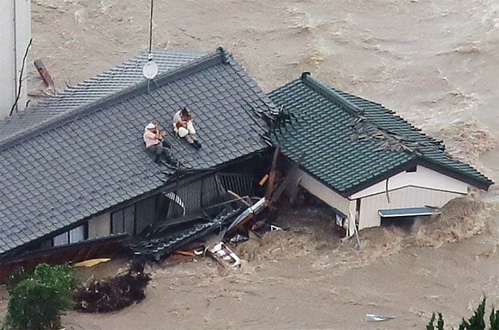 Local residents wait to be rescued on the roof of their home in a flooded area in Joso, Ibaraki Prefecture, on September 10, 2015. (AFP Photo)