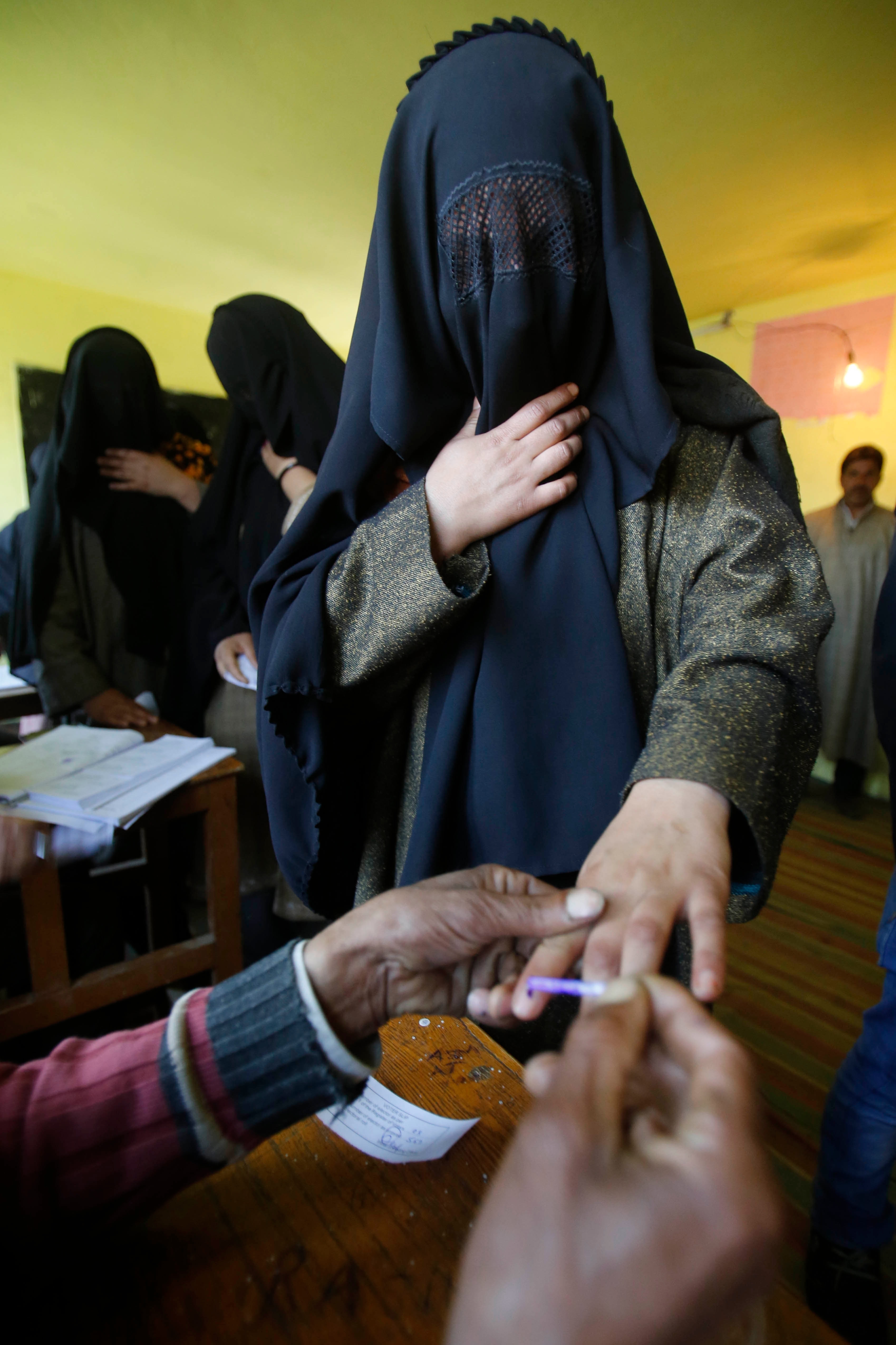 A polling officer marks the finger of a Kashmiri woman with indelible ink inside a polling station in Bragpora, some 65 kilometers south of Srinagar. Kashmir elects only six members for the 543-member strong Parliament, but voting there will take place over several days due to security concerns.