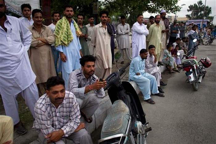 People gathered outside Kamra airbase. The military's media arm told reporters that the situation at the Kamra airbase was under control and that troops were conducting a search operation to ascertain if any more terrorists were inside the complex. There was no official word on whether some attackers had escaped. (Image: Associated Press)