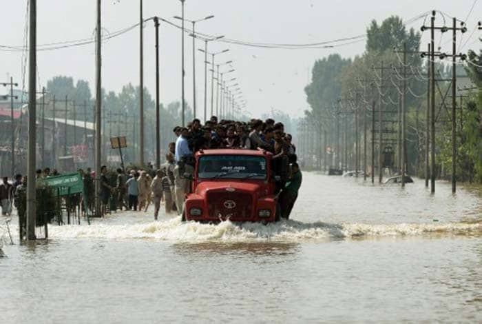 Kashmiri people travel on a truck along a flooded street in Srinagar on September 10, 2014. (Agence France-Presse)