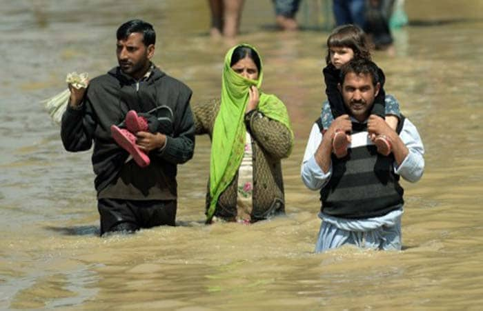 A Kashmiri family walks through the floodwaters in Srinagar on September 10, 2014. (Agence France-Presse)