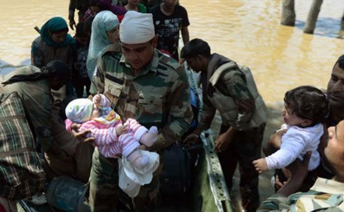 Indian military officers carries a rescued Kashmiri baby from a boat moored in the floodwaters in Srinagar on September 10, 2014. (Agence France-Presse)