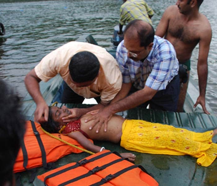 Bystanders and rescue personnel attempt to revive a child at The Thekkady Tiger reserve, some 240 kilometres (149 miles) from Thiruvananthapuram on September 30, 2009, after a boat accident. (AFP Photo)