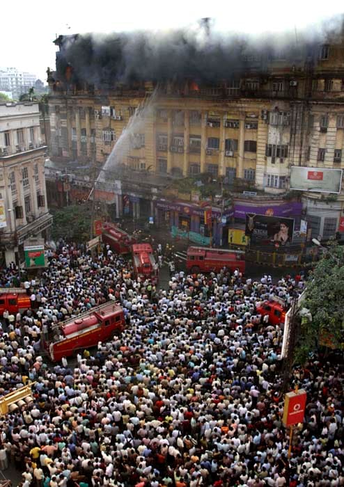 A major fire broke out in the multi-storied heritage building, Stephen's Court, in Kolkata's busy Park Street area on Tuesday that killed 24 people and left about 18 injured, eight of whom are critical.<br><br>The firemen put up ladders to rescue people who had scrambled out from windows on ledges and recovered 17 bodies overnight as they went from door to door on the 5th, 6th and 7th floor of the building. Only 12 of these bodies have been identified so far.<br><br>Most of the people were injured when they tried to jump to safety. (AP Photo)