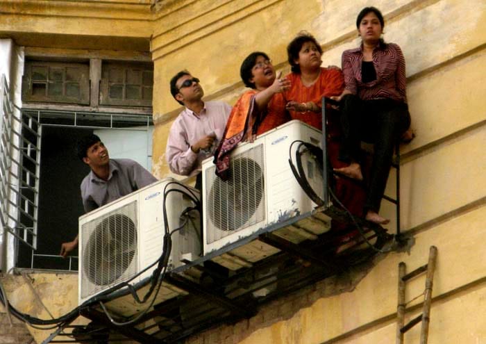 The fire, that started in the lift soon spread upwards and sideways and forced people out of windows onto narrow parapets and ledges as they waited to be rescued.(AP Photo)