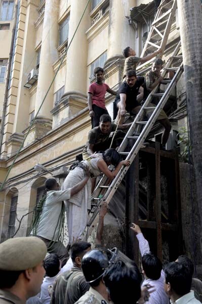 Panicky people trapped in the building tried to escape by climbing down rickety ladders or even a rope. (AFP Image)