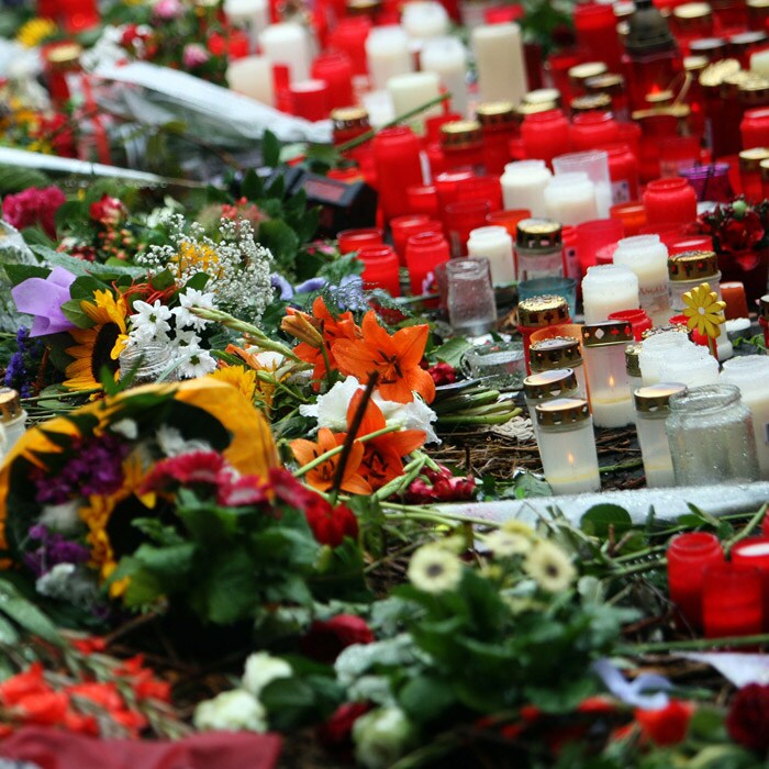 The Memorial Day brought many to the spot, friends and family members of those who died in the pandemonium placed wreaths and lit candles.<br> <br>In this picture an Australian flag can be seen next to candles and flowers at a make-shift memorial site at the entrance of the tunnel. (AFP Photo).