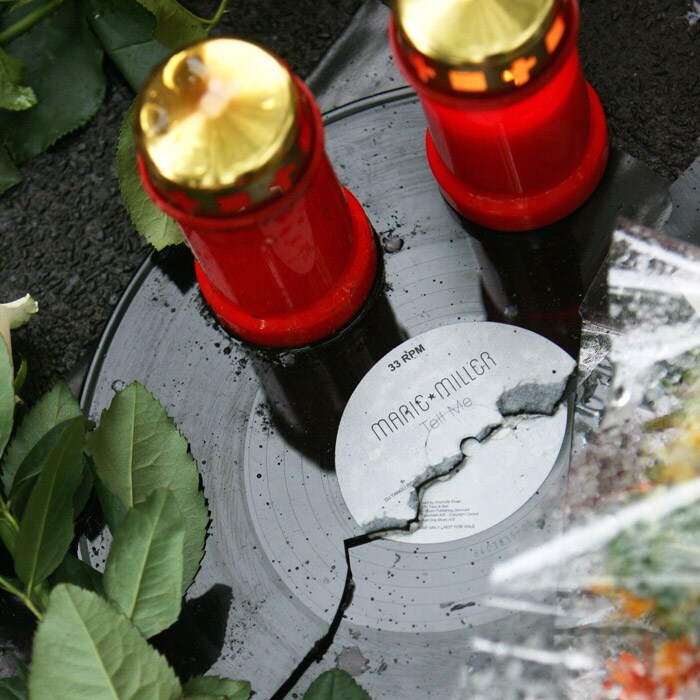 A broken record can be seen along with candles and flowers at the make-shift memorial site at the tunnel. (AFP Photo).