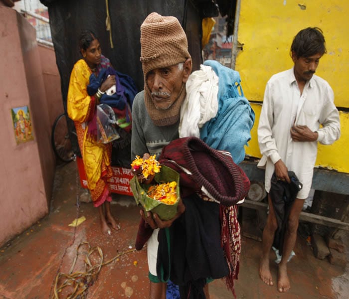 A devotee waits with flowers to offer to the Ganges ahead of the Kumbh Mela in Haridwar. <br/><br/>Thousands of devotees are gathering in one of north India's holiest cities. Organizers say this is the largest religious gathering in the world that will attract more than 10 million people. (AP Photo)