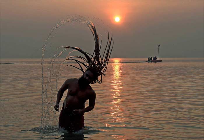 A sadhu takes a holy dip in the river Ganga on Sagar Island in West Bengal on Tuesday. (Press Trust of India)