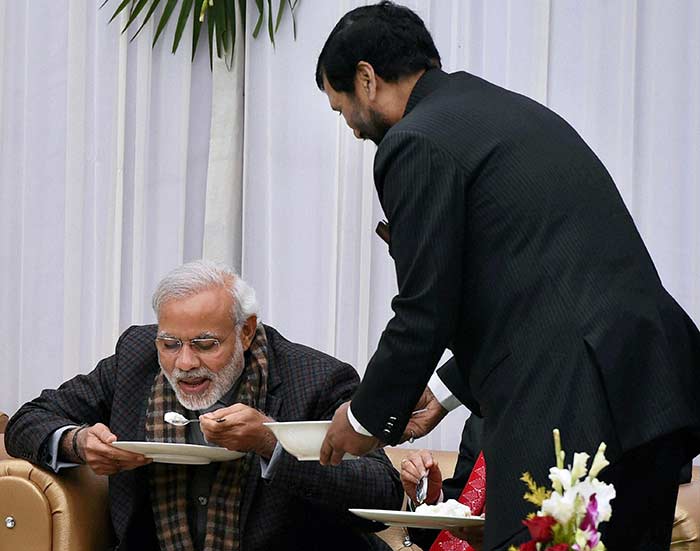 Prime Minister Narendra Modi enjoying a traditional food item at Makar Sankranti celebrations, at his residence in New Delhi. (Press Trust of India)