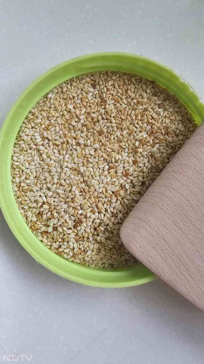 कढ़ाही में तिल डालकर धीमी आंच पर हल्का सुनहरा होने तक भून लें और अलग रख दें.