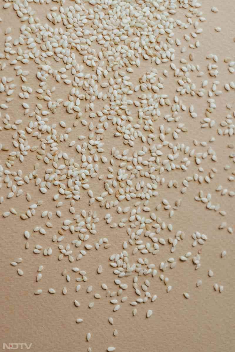 अब भुने तिल और कुटे ड्रायफ्रूट्स डालकर तेजी से चलाएं ताकि मिश्रण एक जैसा हो जाए.