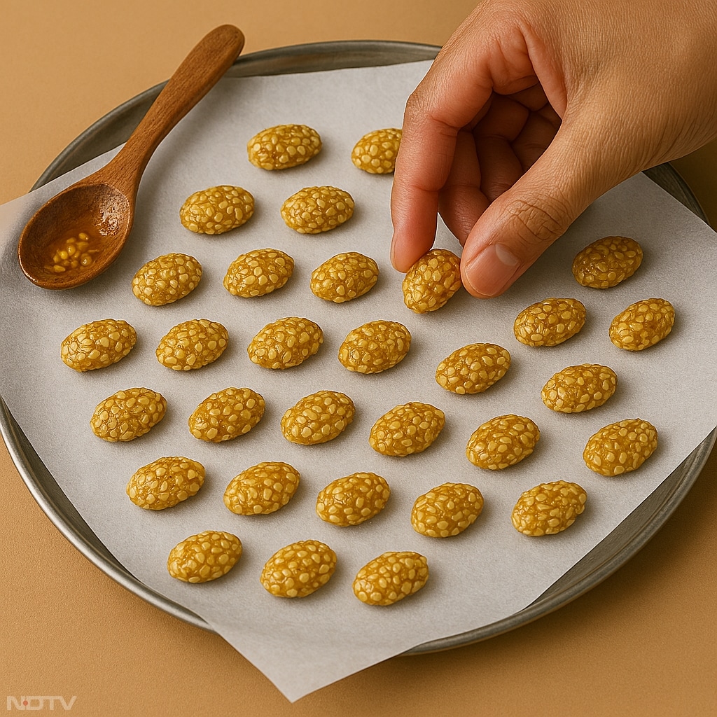 चिकनी थाली या बटर पेपर पर छोटे छोटे हिस्से डालकर रेवड़ी का आकार दें.