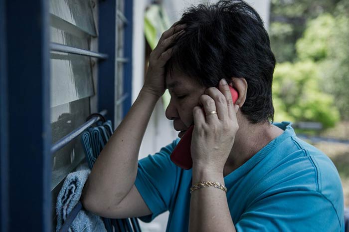 The mother of a missing passenger talks on a mobile phone at her house in Kuala Lumpur on March 8, 2014. The Vietnamese state media reported that the Boeing 777-200ER flight crashed into the South China Sea on Saturday.