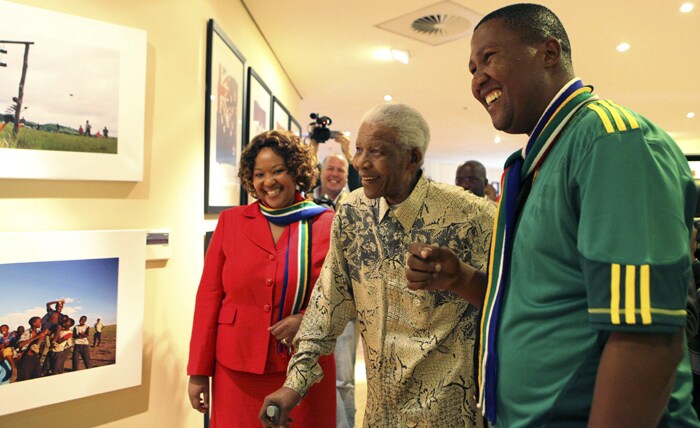 The foundation says Mandela and his family were "torn up" by the accident and that Mandela would be at the ceremony in spirit. Foundation spokesman Sello Hatang asked that the Mandela family be given space to mourn.<br><br> Seen here, Nelson Mandela is being shown the exhibition by his grandson Chief Nkosi Zwelivelile Mandela and South African firstlady Madiba Zuma in Houghton.