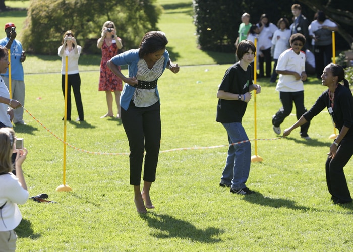 Not giving up despite her unsuccessful double dutch round, she kicked off her shoes and tried jumping into a single swinging rope. That didn't go much better. (AP Photo)