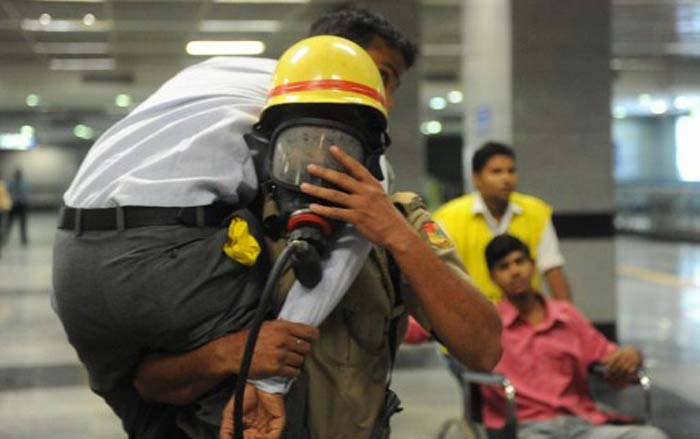 Officers from the National Disaster Response Force (NDRF) attend to a wounded passenger on a train platform during the mock drill. (AFP image)