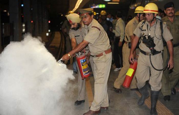 Police use a fire extinguisher on a train platform at a metro station during the mock drill. (AFP image)