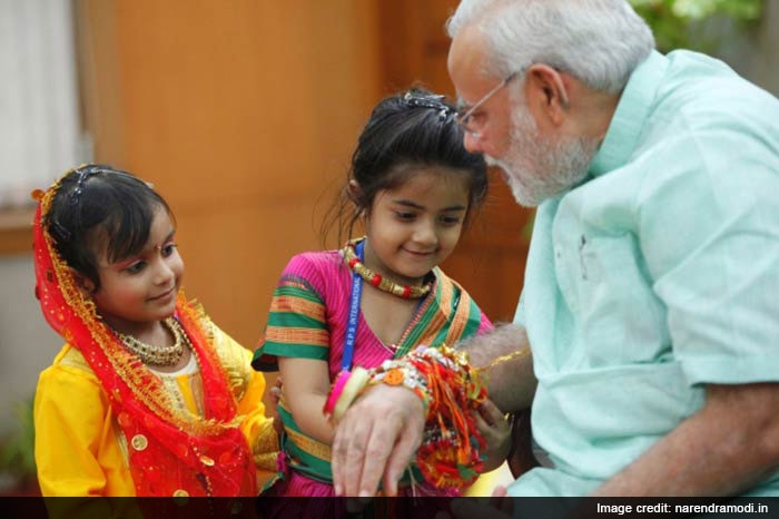 Children tie rakhi to the Prime Minister on the Rakshabandhan festival.