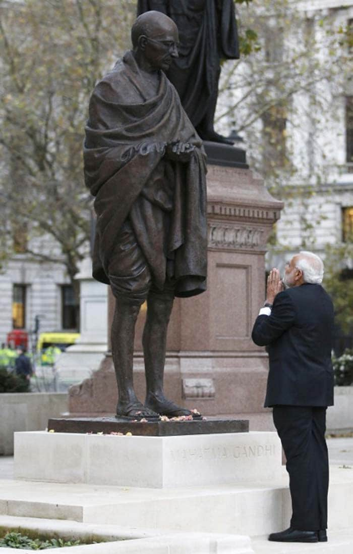 Prime Minister Narendra Modi (R) pays homage in front of a statue of Mahatma Gandhi in Parliament square in London on November 12, 2015. (AFP Photo)